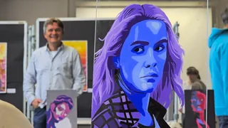 Ein blaues Porträt auf einer Glasscheibe in der Kunstausstellung.